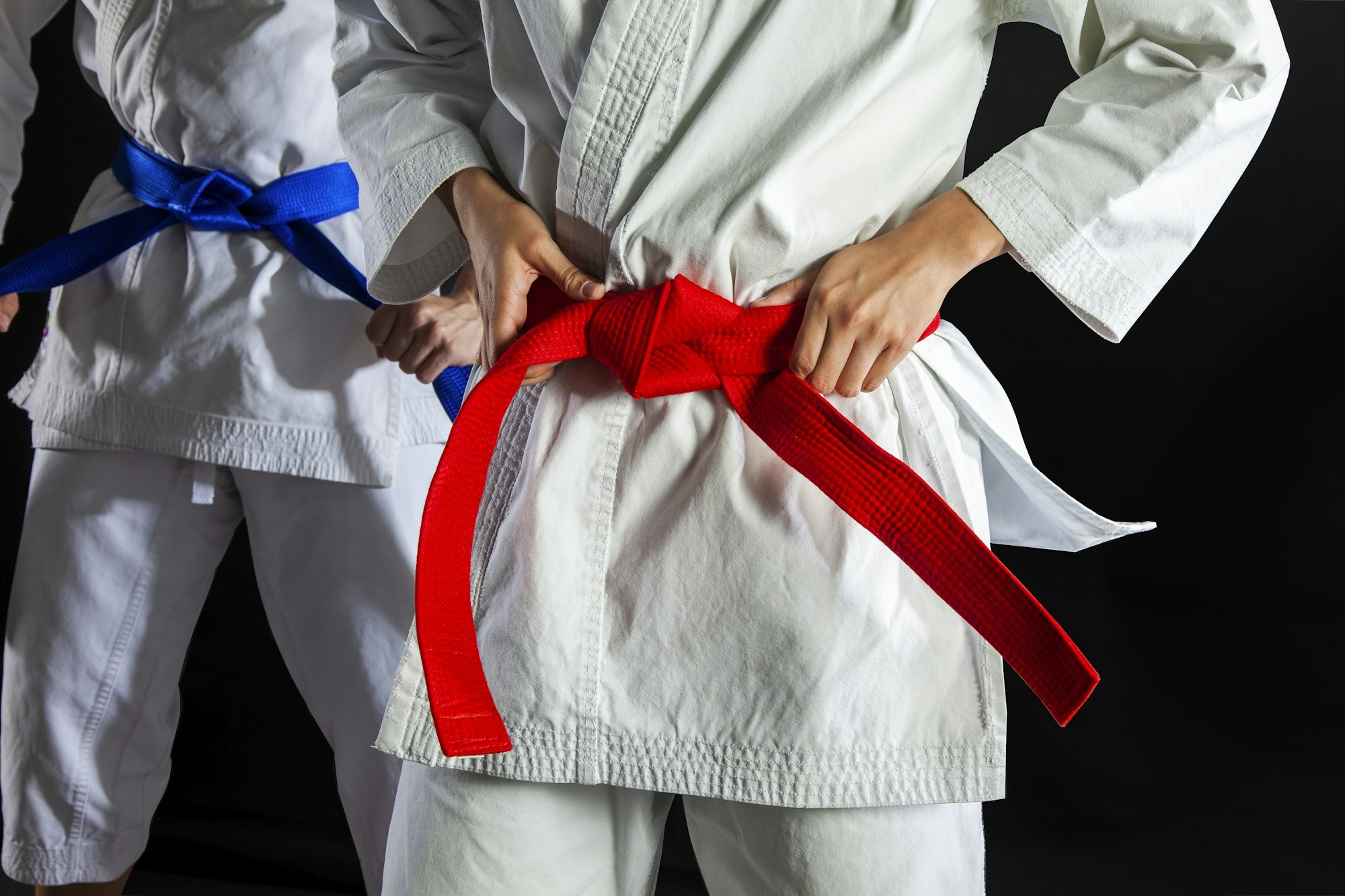 Guy with a karate gi and a red belt practicing his karate training